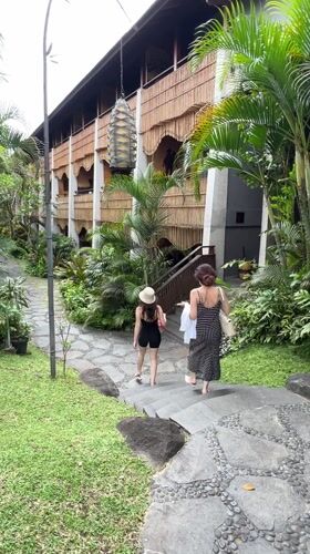 Woman performs early morning yoga backbend on Ubud balcony
