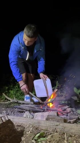 Campfire, fishing, and grilling by a Bulgarian lake at dusk