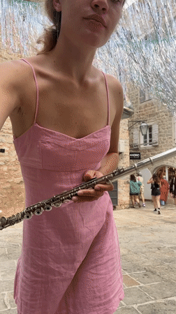 Woman performs flute music in Budva square