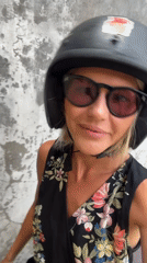 Woman in motorcycle gear filmed against wall in North Kuta