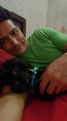 Man shares quiet moment with pet dog on bed