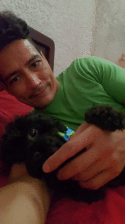 Man shares quiet moment with pet dog on bed