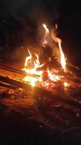 Nighttime open fire burning amid debris in Lhokseumawe