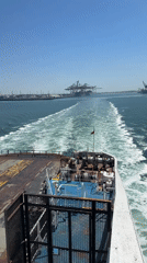 Ship departs French port under sunny skies near Loon-Plage