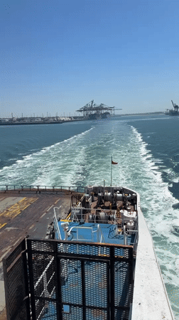 Ship departs French port under sunny skies near Loon-Plage