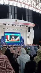 Graduation ceremony held in auditorium with hijab-wearing attendees
