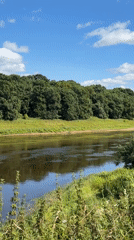 Historic riverside church ruins and calm river views on a sunny morning