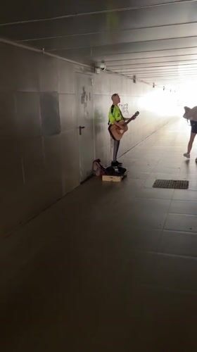 Street musician performs acoustic guitar in Krasnodar underpass