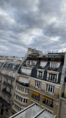 Rooftop views across Paris as the sun sets through clouds