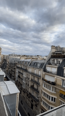 Rooftop views across Paris as the sun sets through clouds