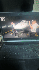 Person watches videos on dusty HP laptop in French hangar