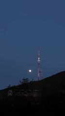 Full moon observed over illuminated Tbilisi TV Tower