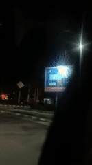Driver navigates illuminated streets in Asenovgrad at night