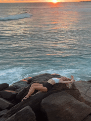 Woman relaxes on coastal rocks in Ahangama, Sri Lanka
