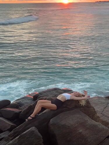 Woman relaxes on coastal rocks in Ahangama, Sri Lanka