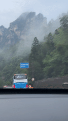 Morning traffic navigates foggy mountain highway in Xiehe, China