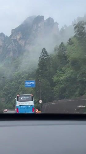Morning traffic navigates foggy mountain highway in Xiehe, China