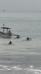Evening beach activities continue under overcast skies in Kuta