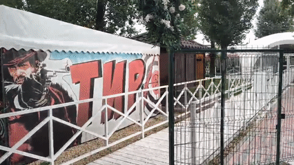 Military-themed fairground with carnival booths and VR pods, Mikhaylovka
