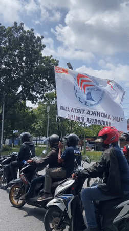 Labor Day motorcycle rally proceeds through Tebel, Indonesia streets