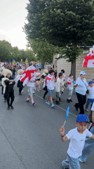 Multicultural parade along Nesebar's Black Sea waterfront at sunset