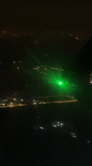 Passenger documents nighttime flight views over Beijing, laser incident