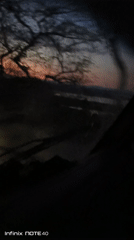 Vehicle travels Venezuelan road at twilight, colorful sky visible