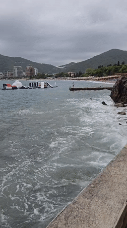 Busy beach day in Budva under overcast summer skies