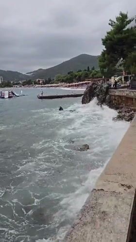 Busy beach day in Budva under overcast summer skies