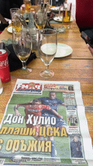 Café patrons gather with soccer newspaper in Sofia