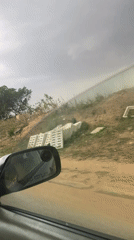 Car travels dirt road through undeveloped Gwarinpa area