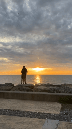Couple embraces on Batumi breakwater at sunset