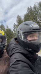 Two motorcyclists ride through forest road near Chaikovsky, Russia