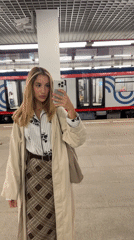 Mirror selfie on a Moscow metro platform, trench coat look
