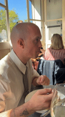 Man in patterned tie dines at London cafe