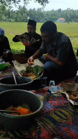 Early morning communal outdoor meal gathering in Lhokseumawe, Indonesia