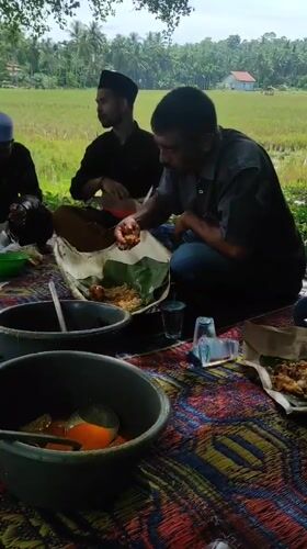 Early morning communal outdoor meal gathering in Lhokseumawe, Indonesia