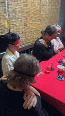 Blindfolded group activity observed around red table in Chiang Mai