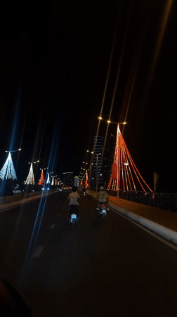 Night traffic flows across illuminated bridge in Nha Trang
