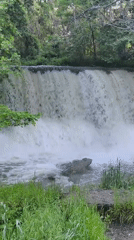 Visitor documents peaceful afternoon at Parvenets waterfall with beverage