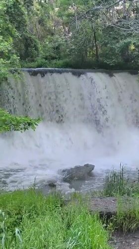 Visitor documents peaceful afternoon at Parvenets waterfall with beverage