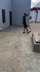 Inline skater performs tricks in Akwanga courtyard recreational area