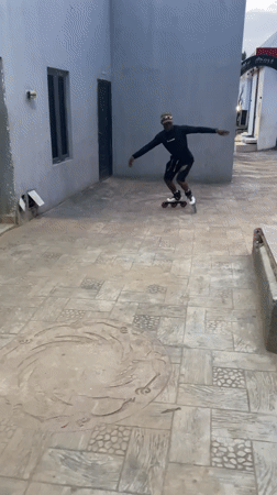 Inline skater performs tricks in Akwanga courtyard recreational area