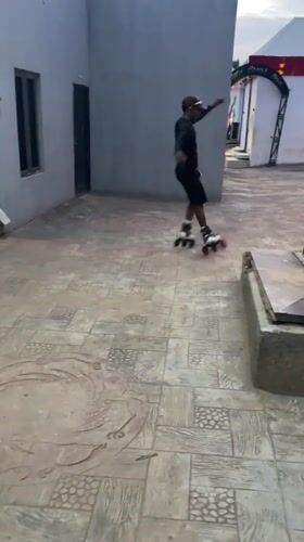 Inline skater performs tricks in Akwanga courtyard recreational area