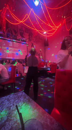 Karaoke night at a neon-lit bar in Chaikovsky, Russia