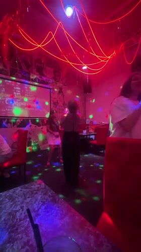 Karaoke night at a neon-lit bar in Chaikovsky, Russia