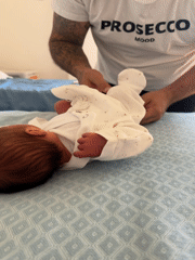 New father tends to newborn in Italian hospital room