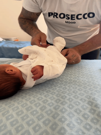 New father tends to newborn in Italian hospital room