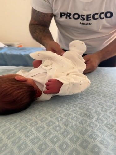 New father tends to newborn in Italian hospital room