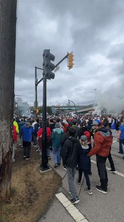 Organized street march moves through downtown Vancouver with flags and smoke